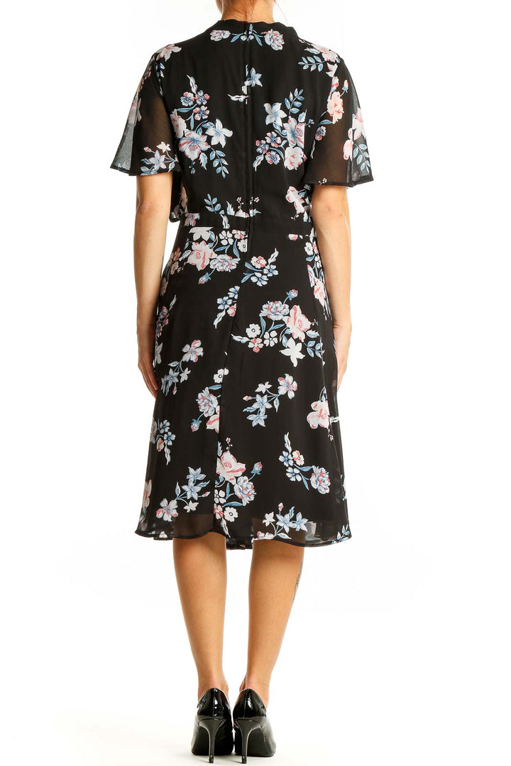 Back view of Torrid black floral midi dress showing flutter sleeves and all-over print