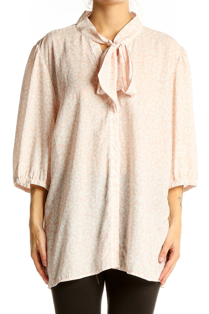 Front view of Eloquii blush polka dot tie-neck blouse with 3/4 sleeves