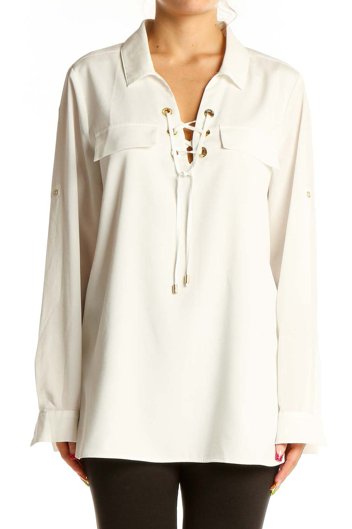 Front view of white Calvin Klein blouse with lace-up V-neck and gold grommets