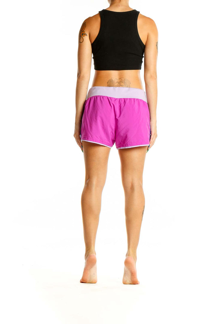 Back view of pink Adidas running shorts on model