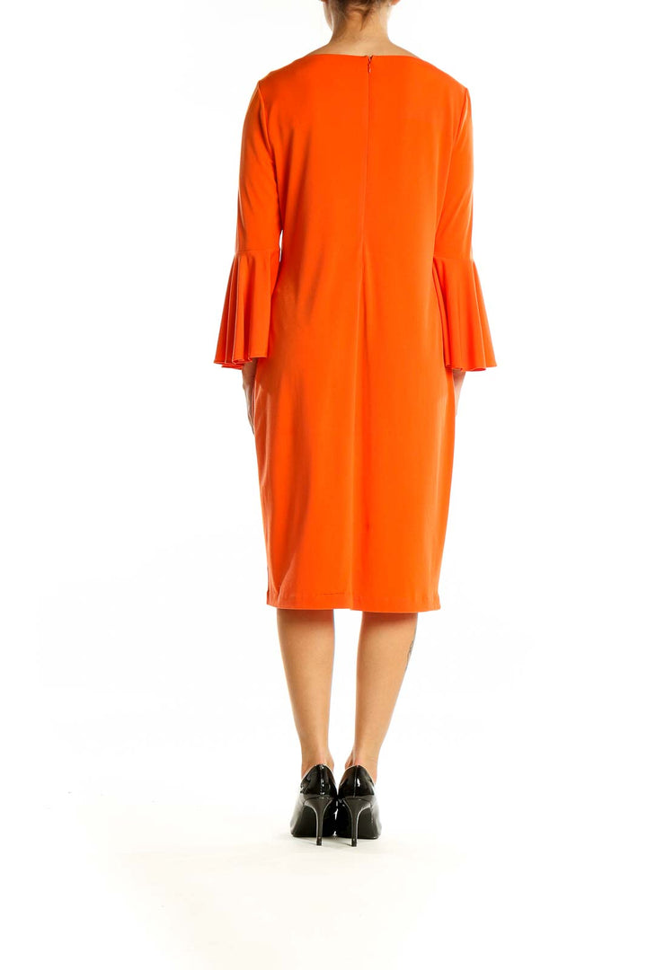 Back view of orange Calvin Klein midi dress showing zipper closure