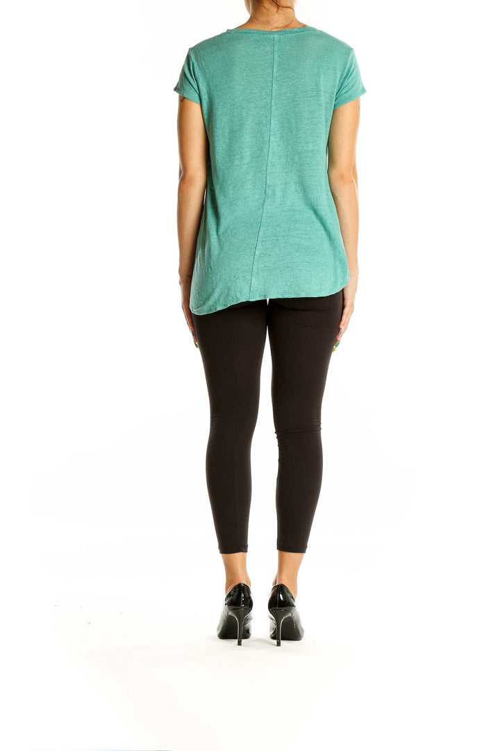 Back view of mint green Tahari linen t-shirt on model with black pants