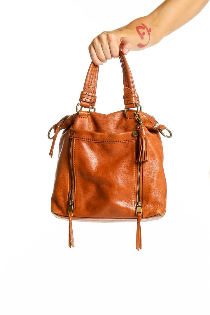 Front view of The Sak tan leather crossbody bag with tassels