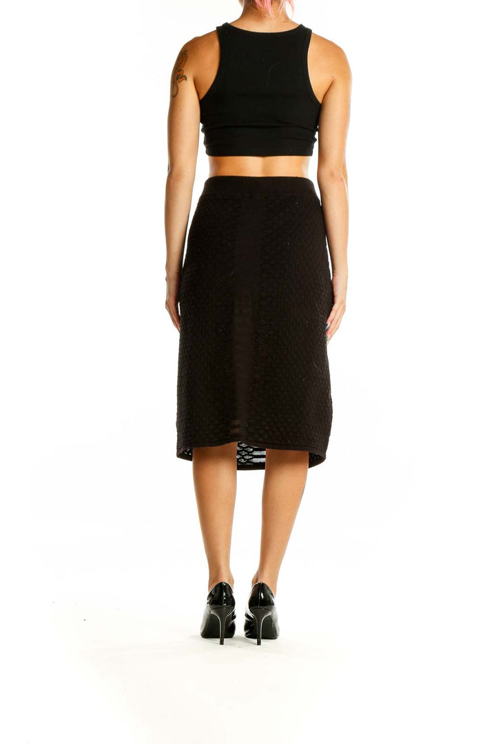 Back view of Calvin Klein black textured midi skirt on model