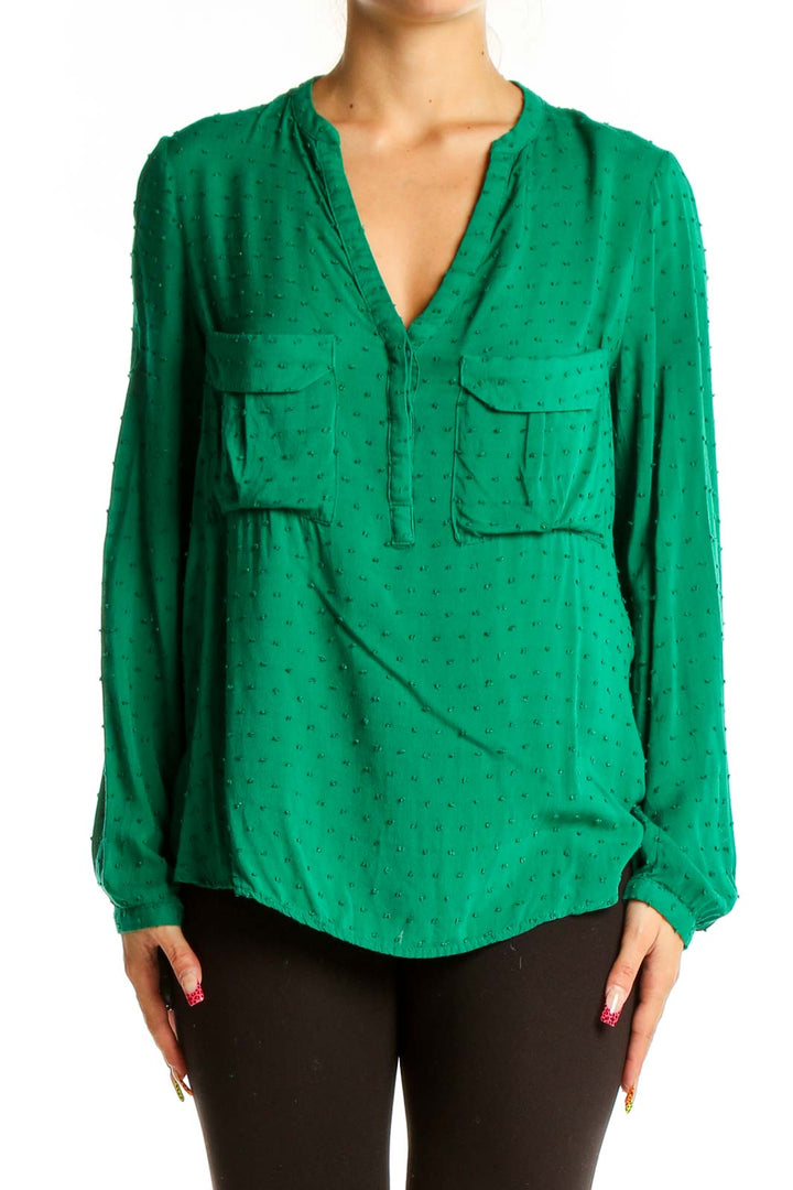 Front view of green dotted rayon blouse with V-neck and front pockets