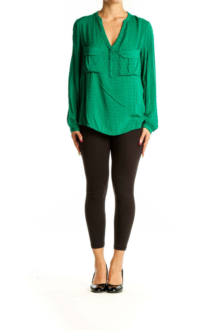 Front view of green dotted rayon blouse with V-neck and front pockets