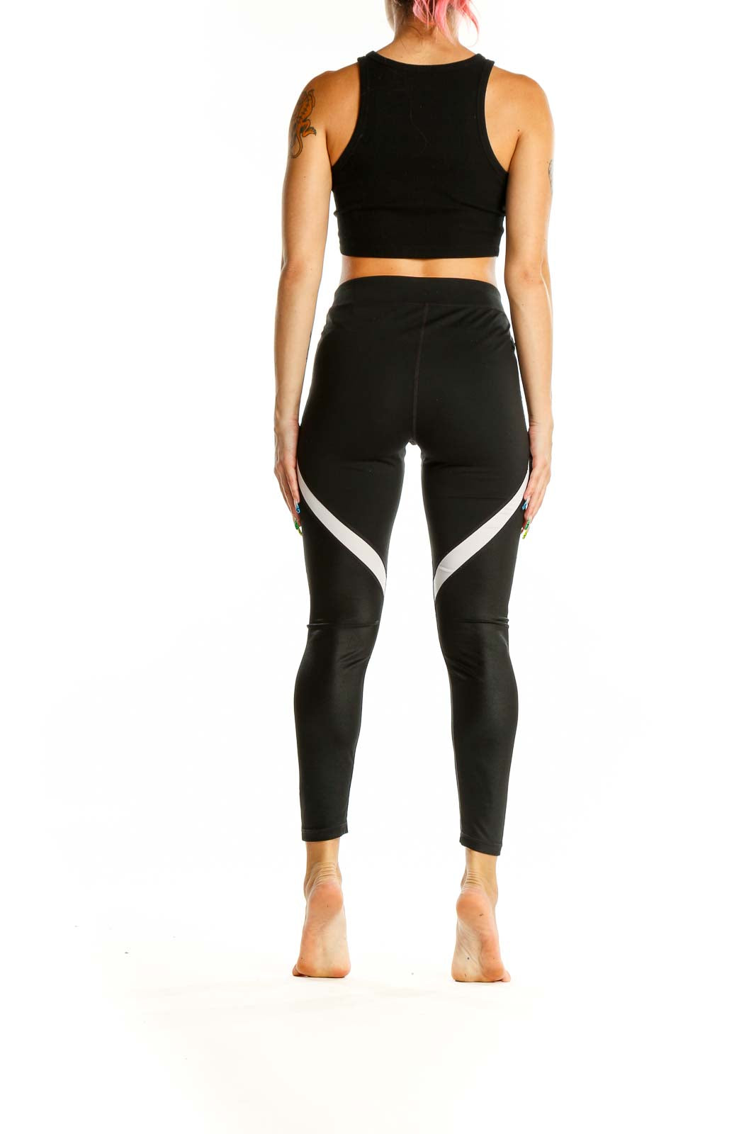 Back view of black GapFit high-waisted leggings showing white side panels