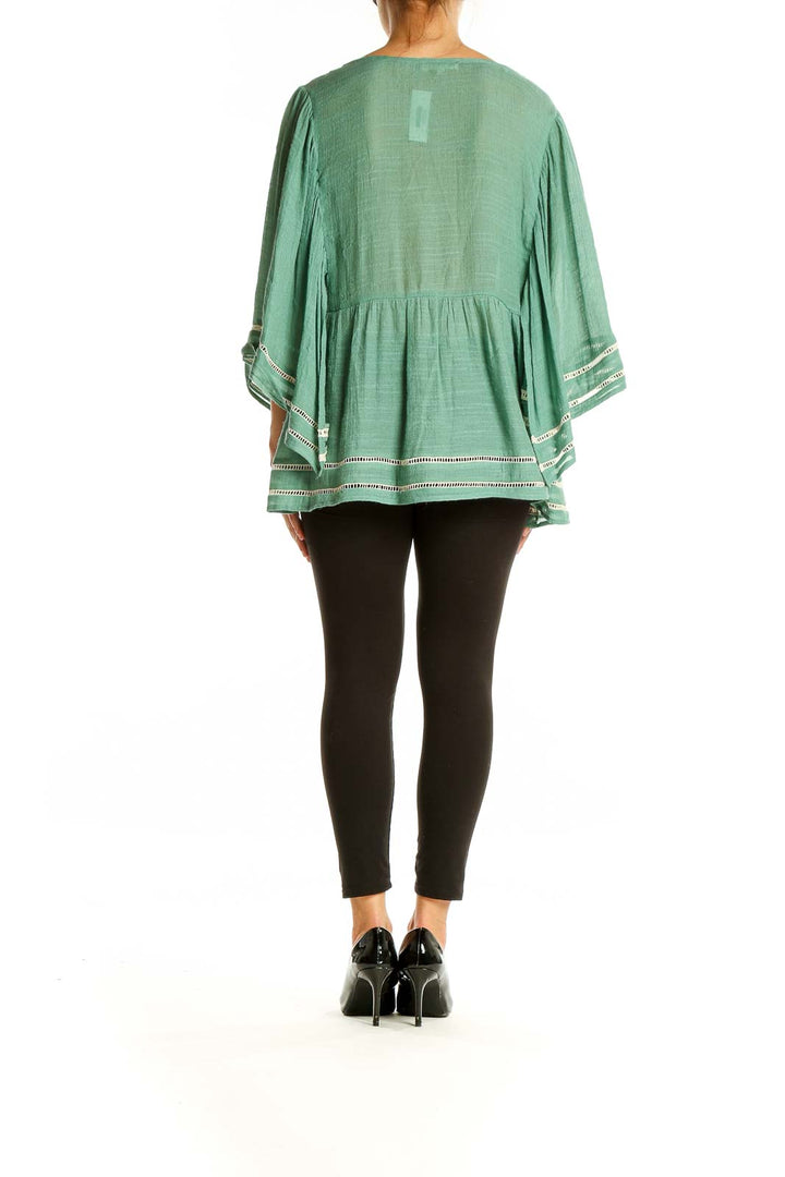 Back view of Entro sage green blouse showing flowy silhouette and bell sleeves