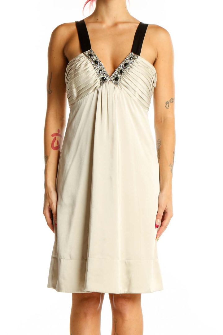 Front view of cream BCBG MaxAzria cocktail dress with embellished V-neckline