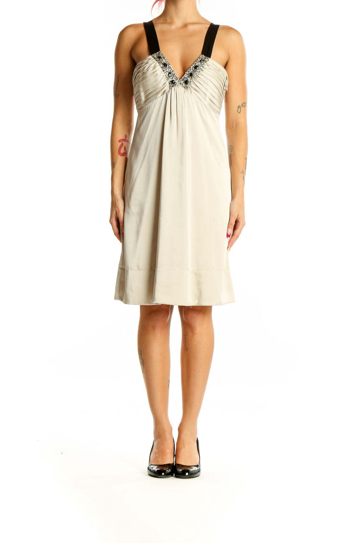 Front view of cream BCBG MaxAzria cocktail dress with embellished V-neckline