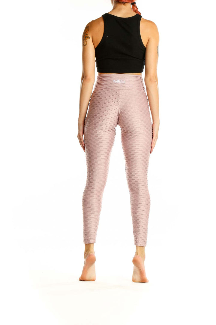 Back view of pink textured high-waist activewear leggings by Booty By Brabants