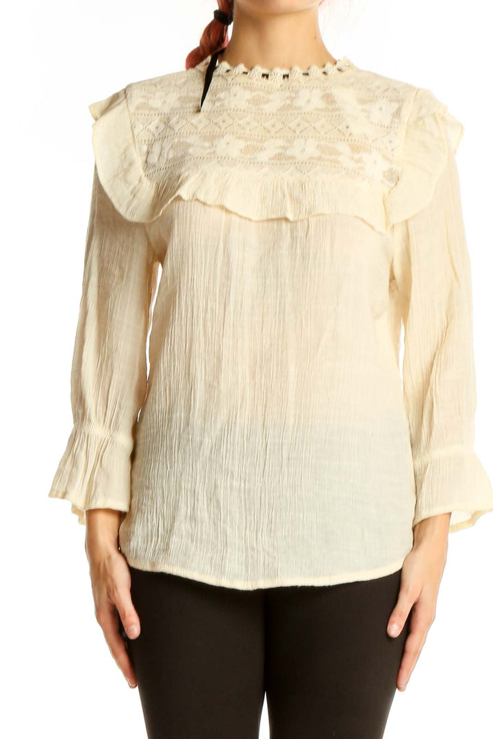 Front view of SilkRoll cream embroidered blouse with ruffles