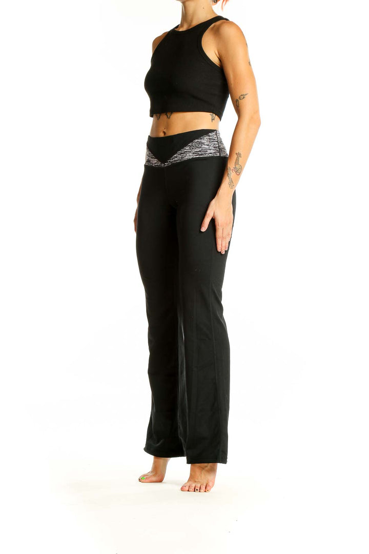 Front view of black Cabi flared yoga pants with heathered waistband