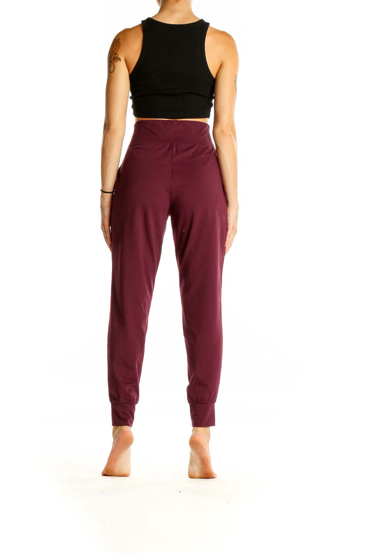 Back view of burgundy GapFit high-waisted jogger pants on model