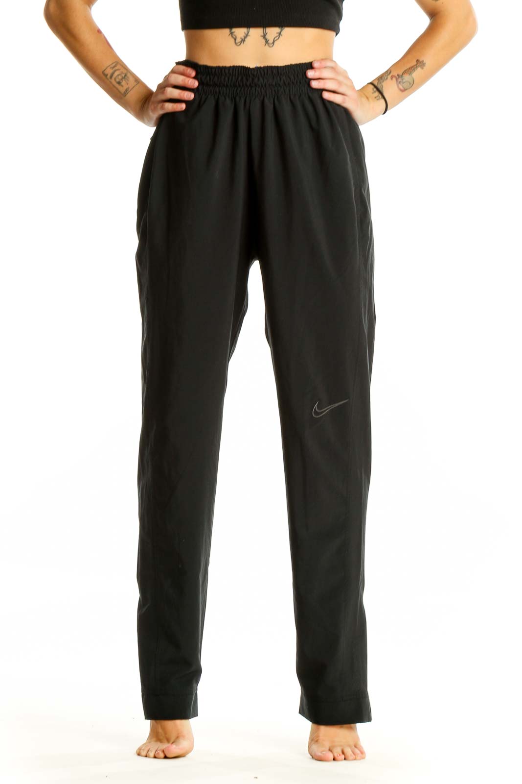 Front view of black Nike activewear pants with elastic waistband