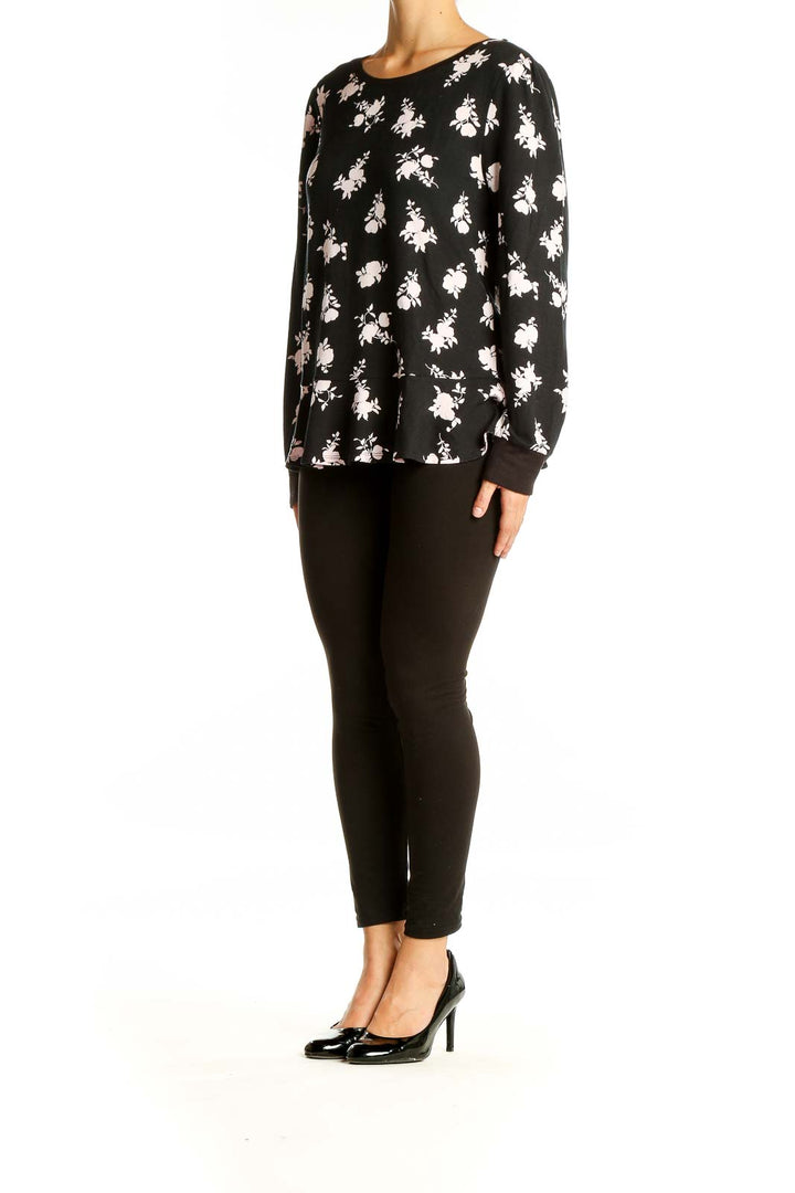 Front view of Kate Spade black floral print long sleeve top with peplum hem