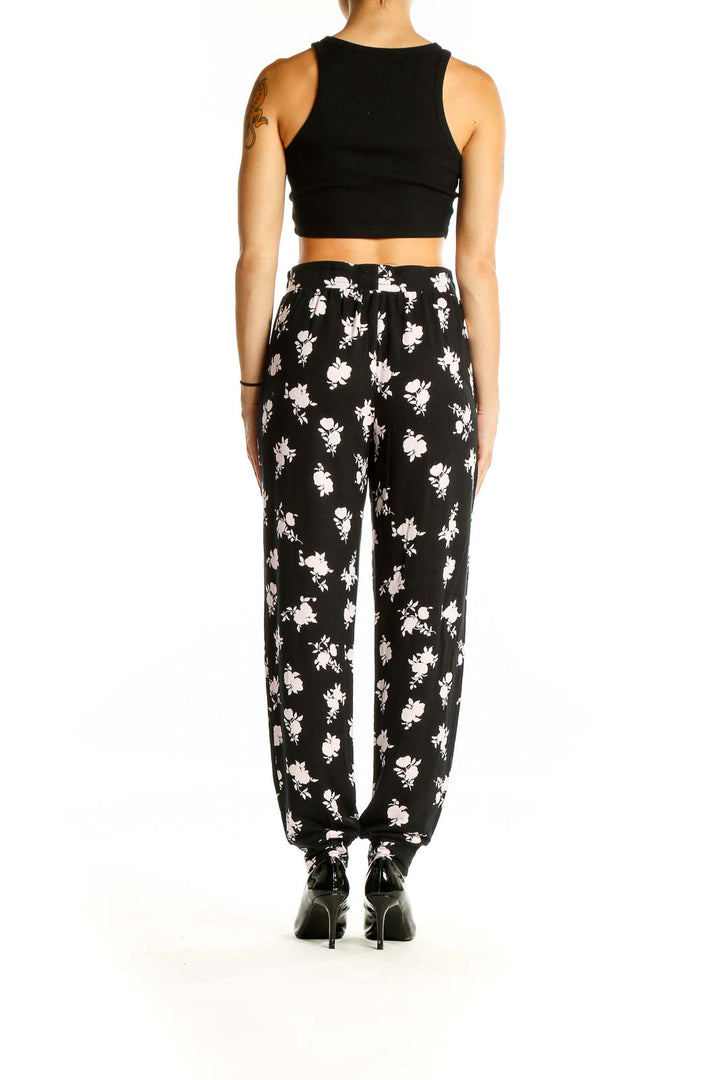 Back view of Kate Spade black floral print pants on model with black crop top