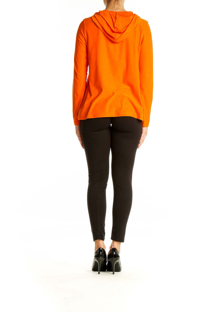 Back view of orange hooded long sleeve activewear top from Beyond Yoga