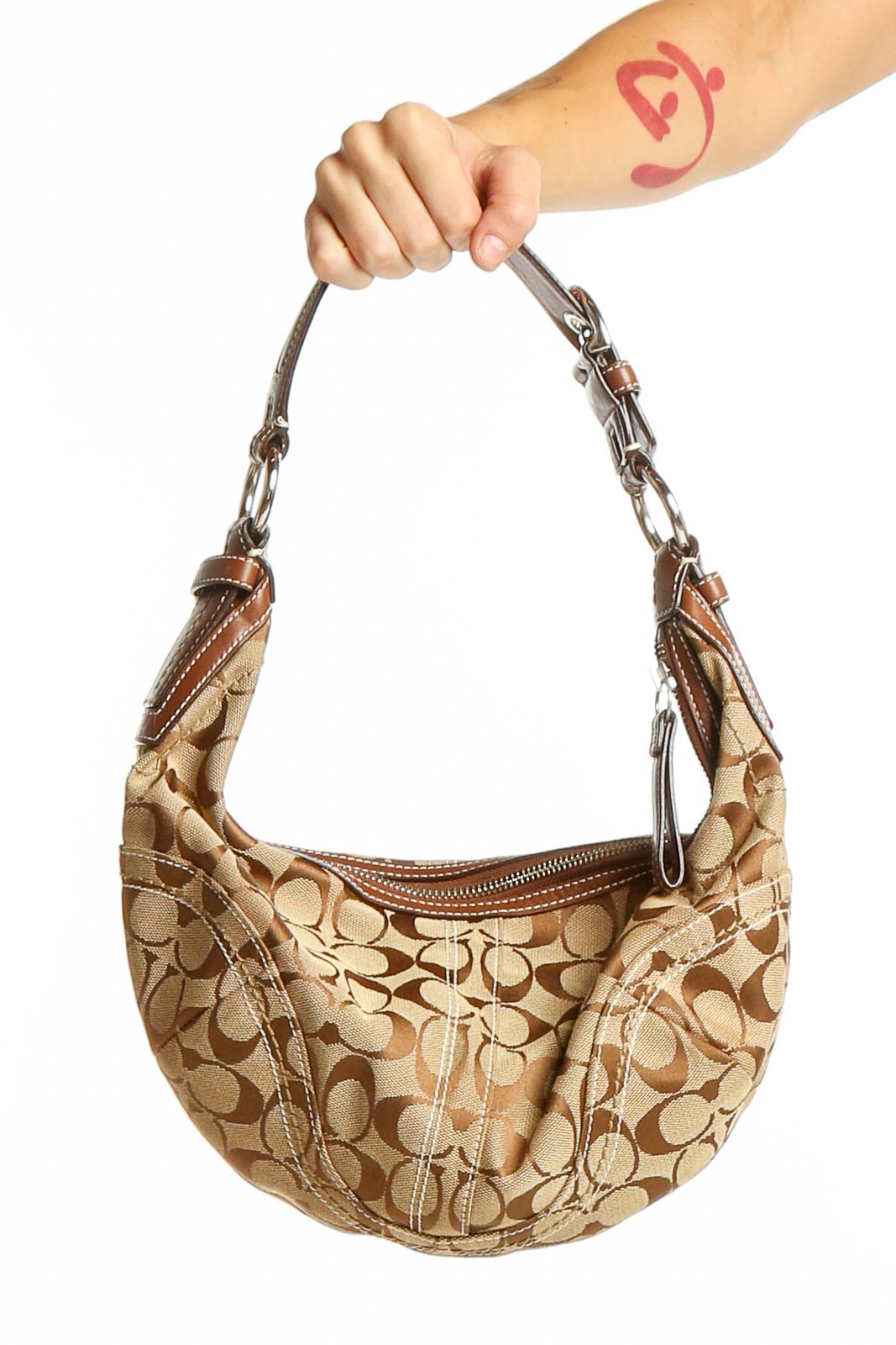 Front view of beige Coach signature canvas hobo bag with leather trim