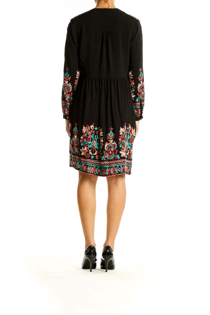 Back view of Floreat black midi dress showing embroidered hem and sleeves