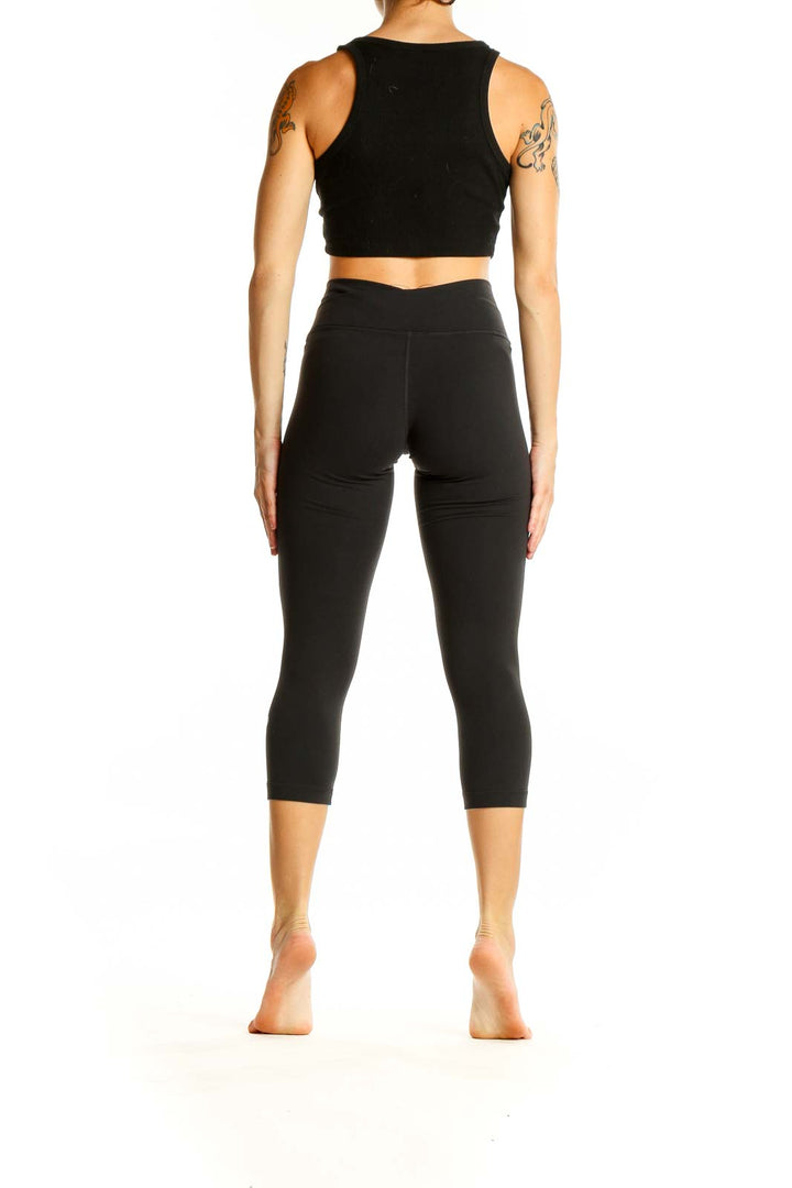 Back view of black Lululemon high-waisted cropped activewear leggings