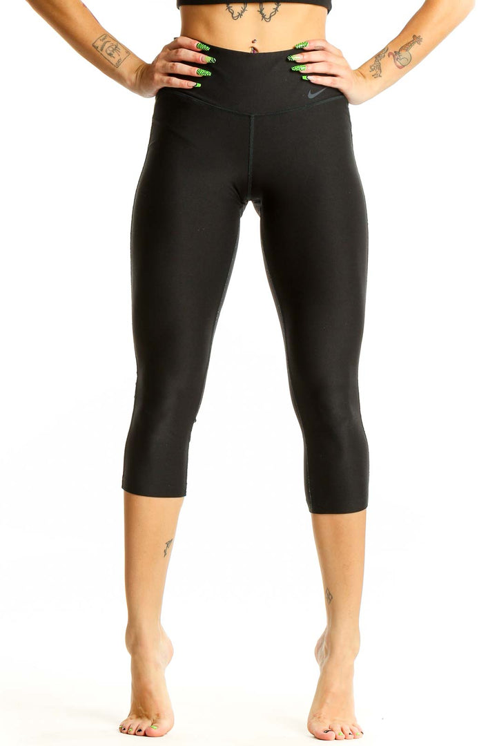 Front view of black Nike high-waisted capri leggings on model