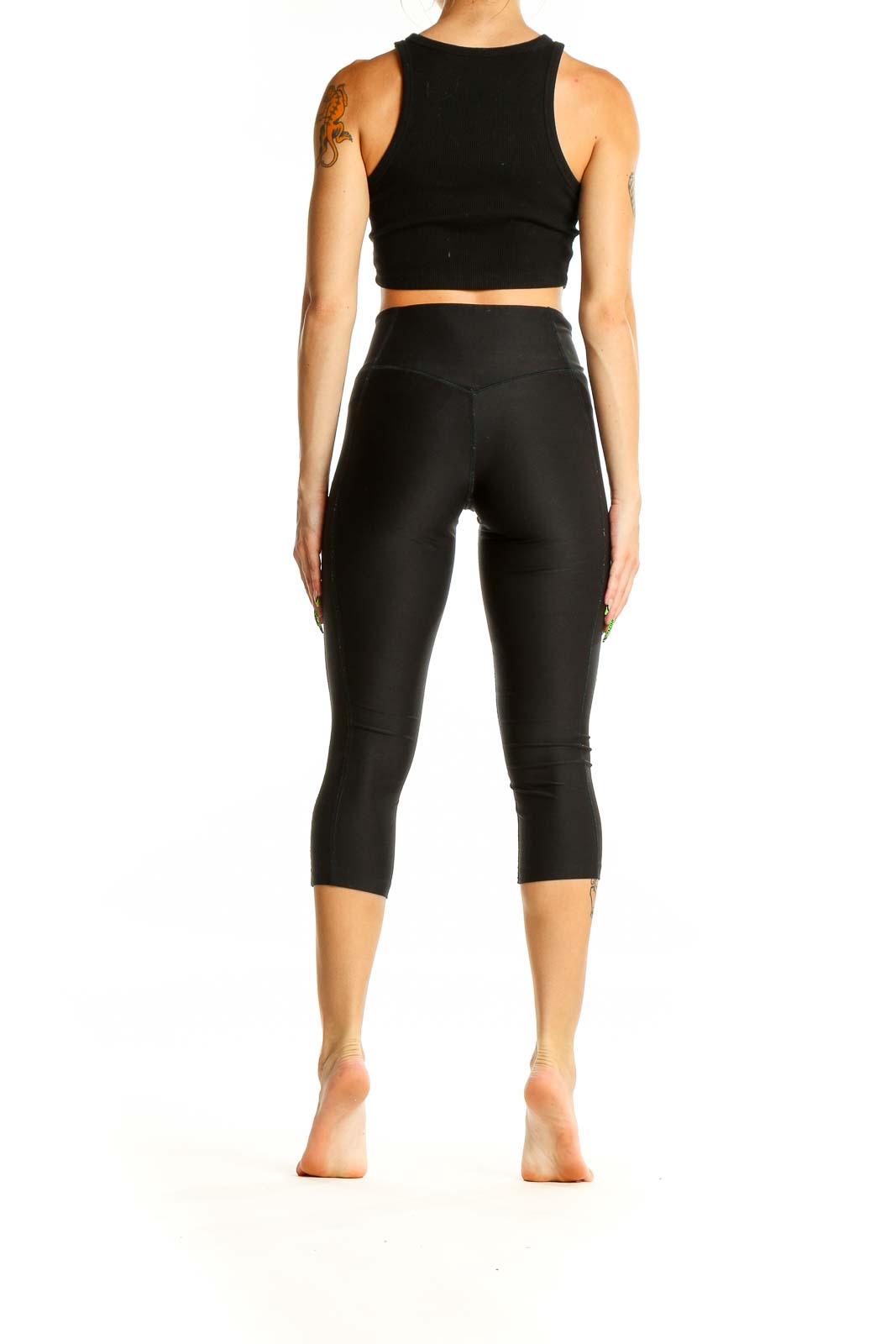 Back view of black Nike high-waisted capri leggings on model