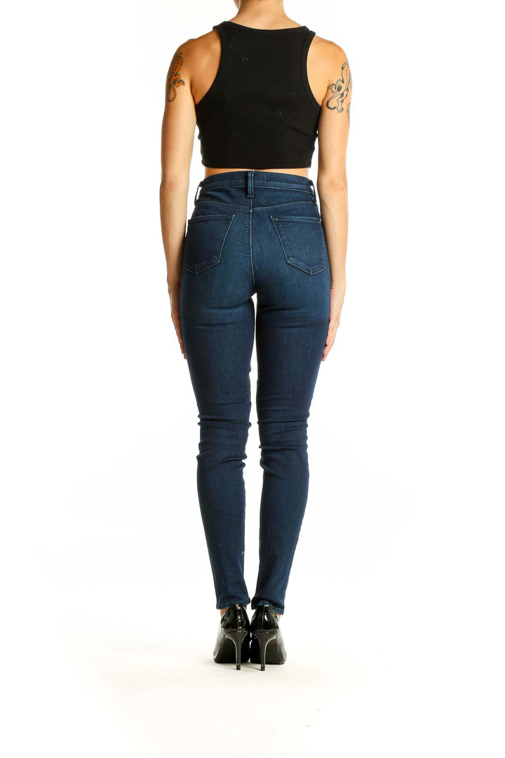 Back view of J Brand dark blue high-waisted skinny jeans on model