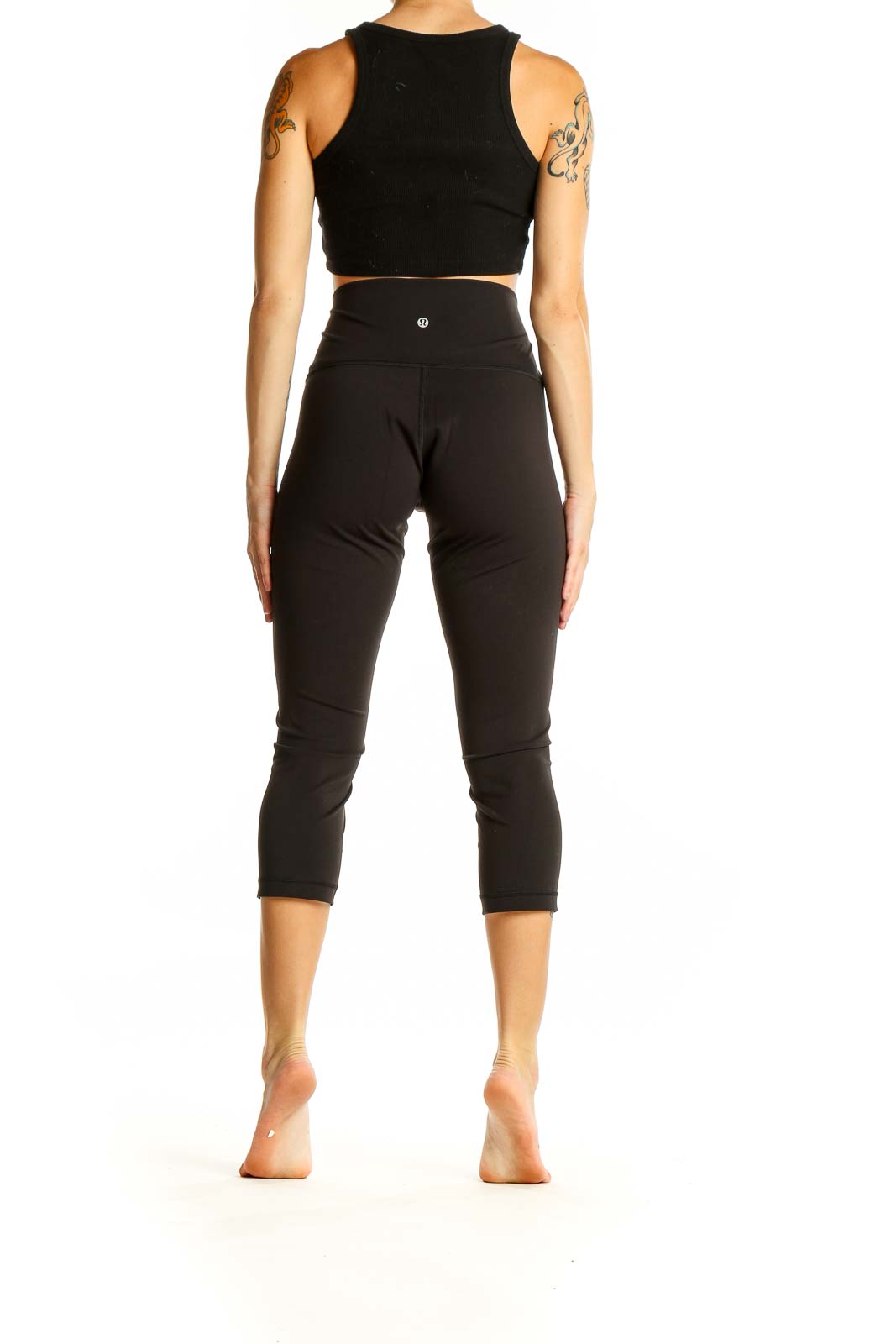 Back view of black Lululemon high-waisted capri leggings on model