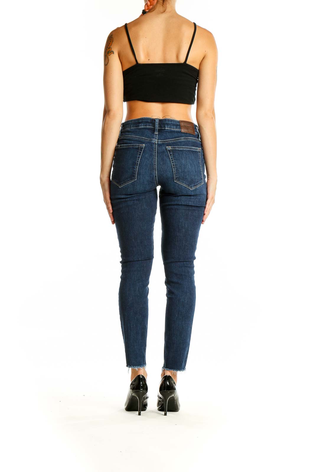 Back view of Lucky Brand dark blue skinny ankle jeans on woman