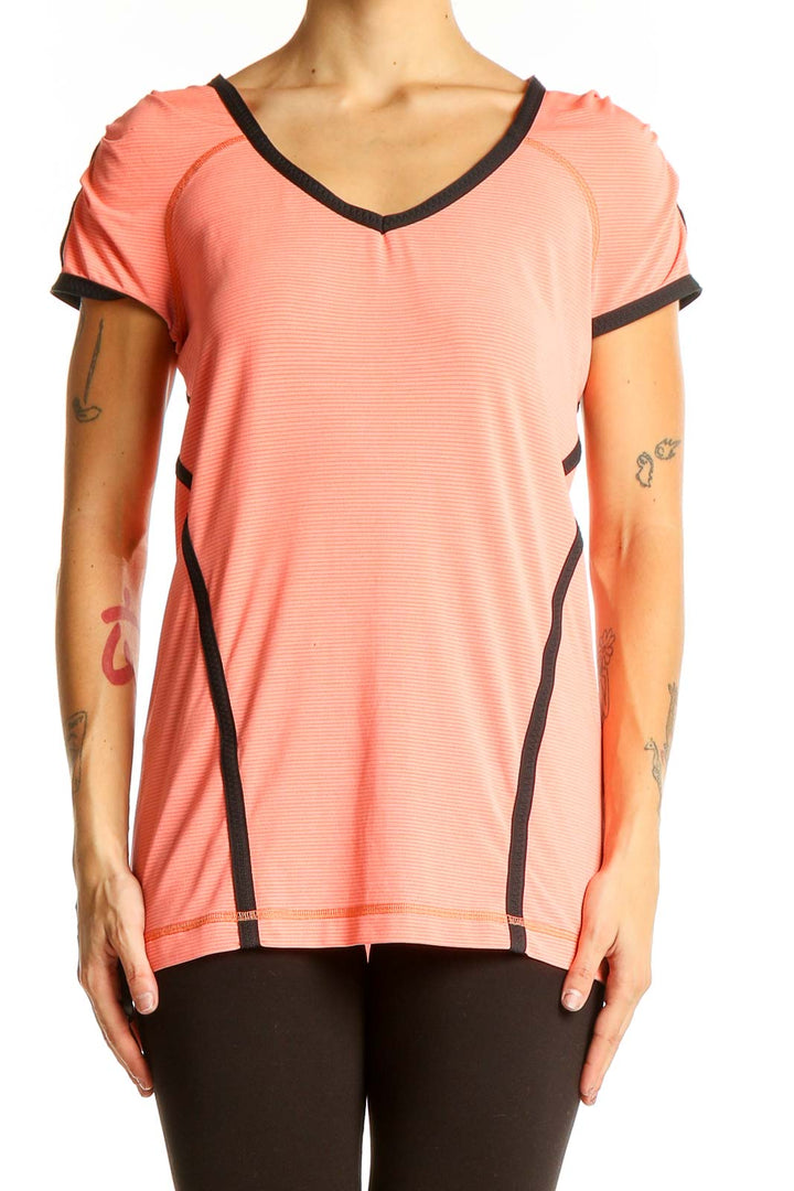 Front view of coral Lululemon athletic top with V-neck and black trim