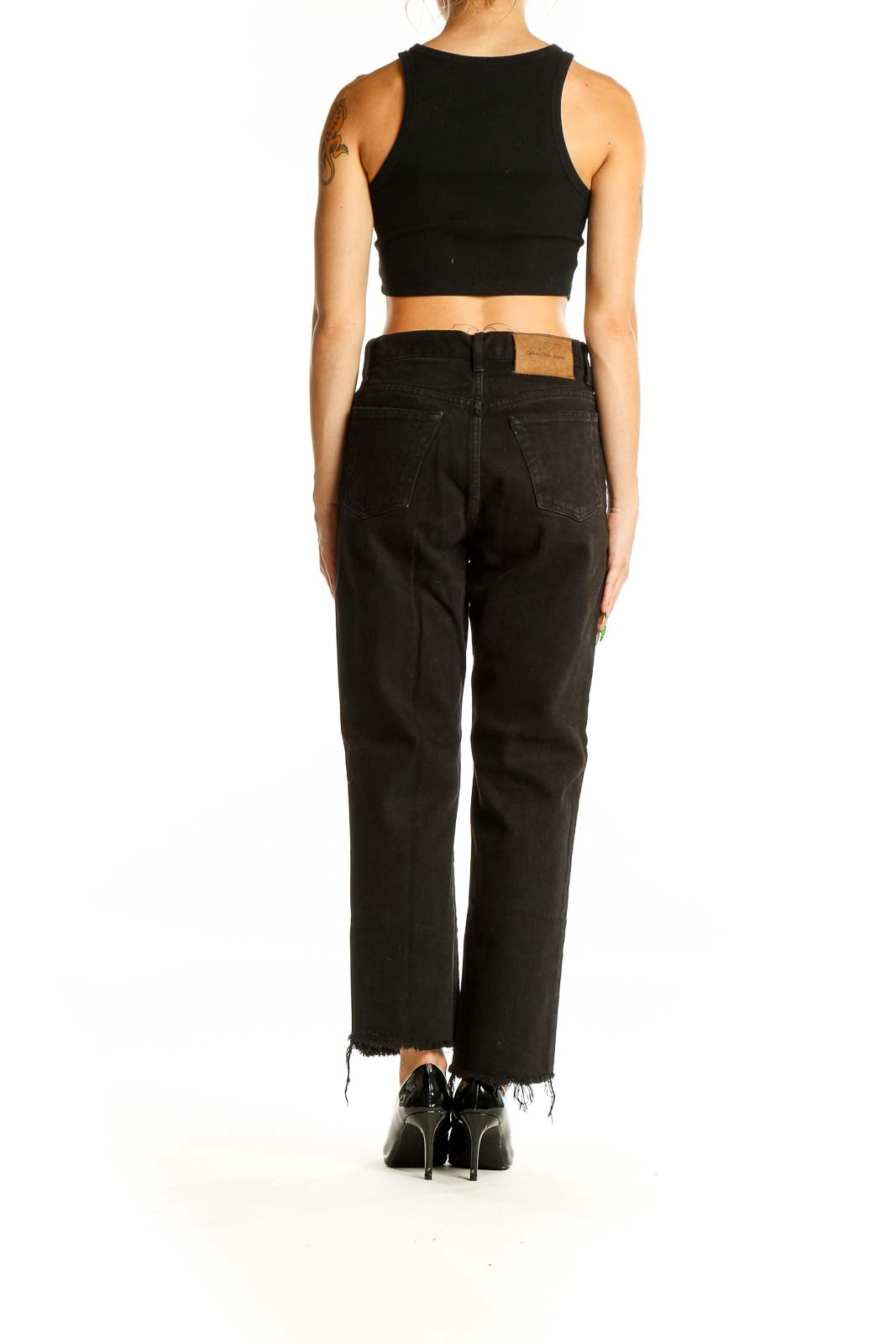 Back view of Calvin Klein black straight leg jeans showing raw hem detail