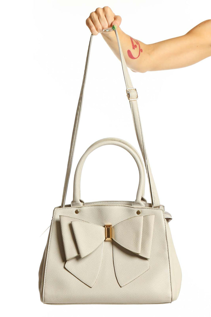 Front view of Grossi cream leather satchel with large bow detail