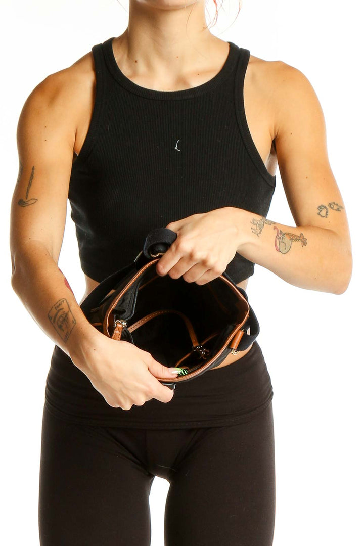 Model holding Michael Kors black leather crossbody bag, showing size and style