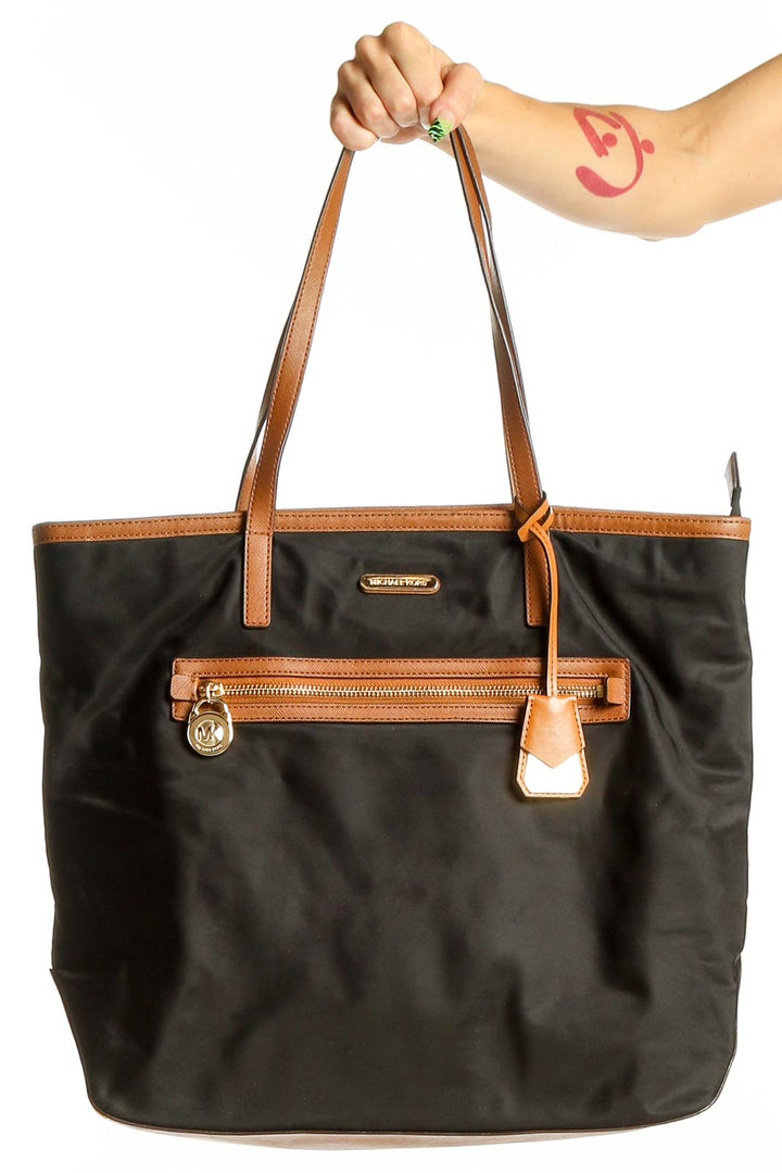 Front view of Michael Kors black leather tote bag with brown trim and gold hardware