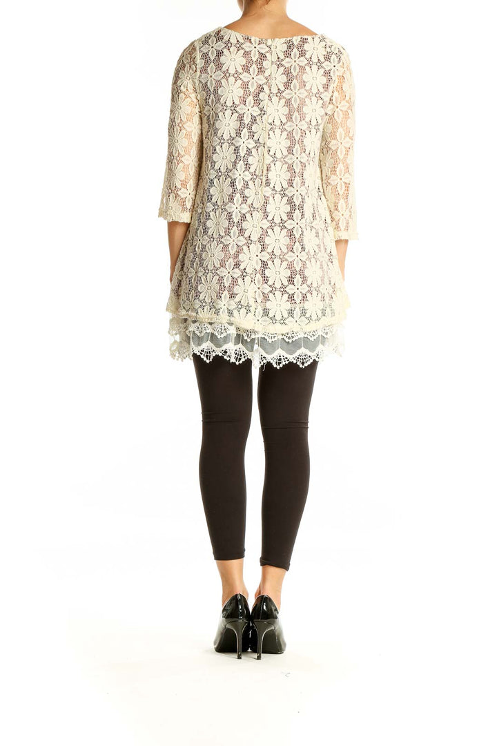 Back view of SilkRoll cream floral lace overlay tunic top showing scalloped hem