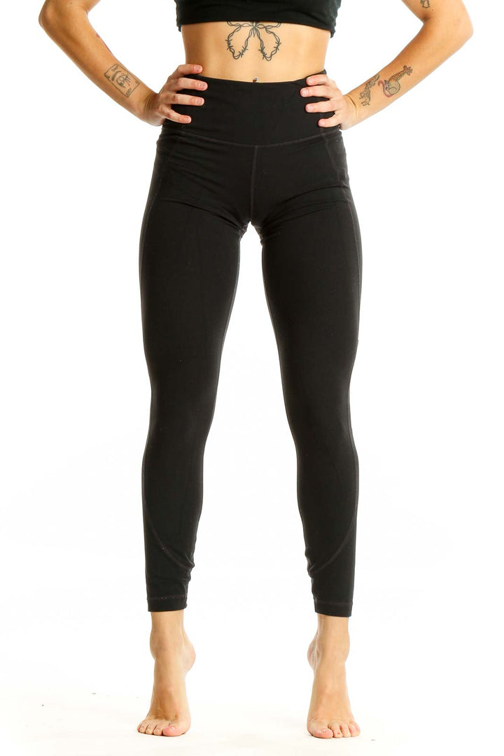 Front view of black high-waisted Athleta performance leggings on model