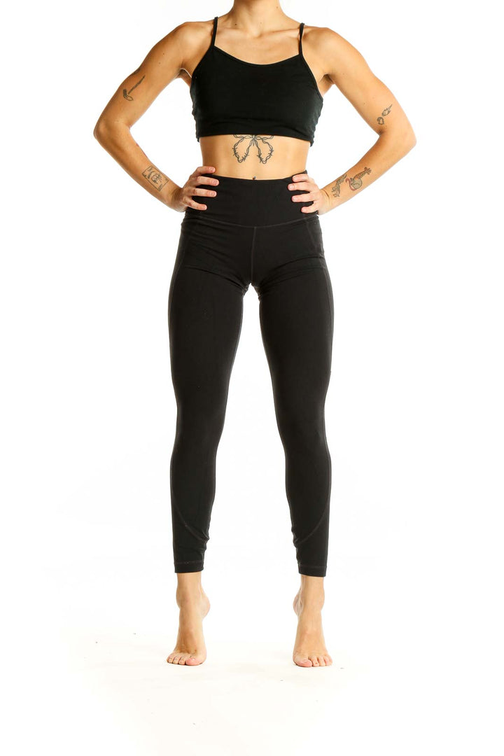 Front view of black high-waisted Athleta performance leggings on model