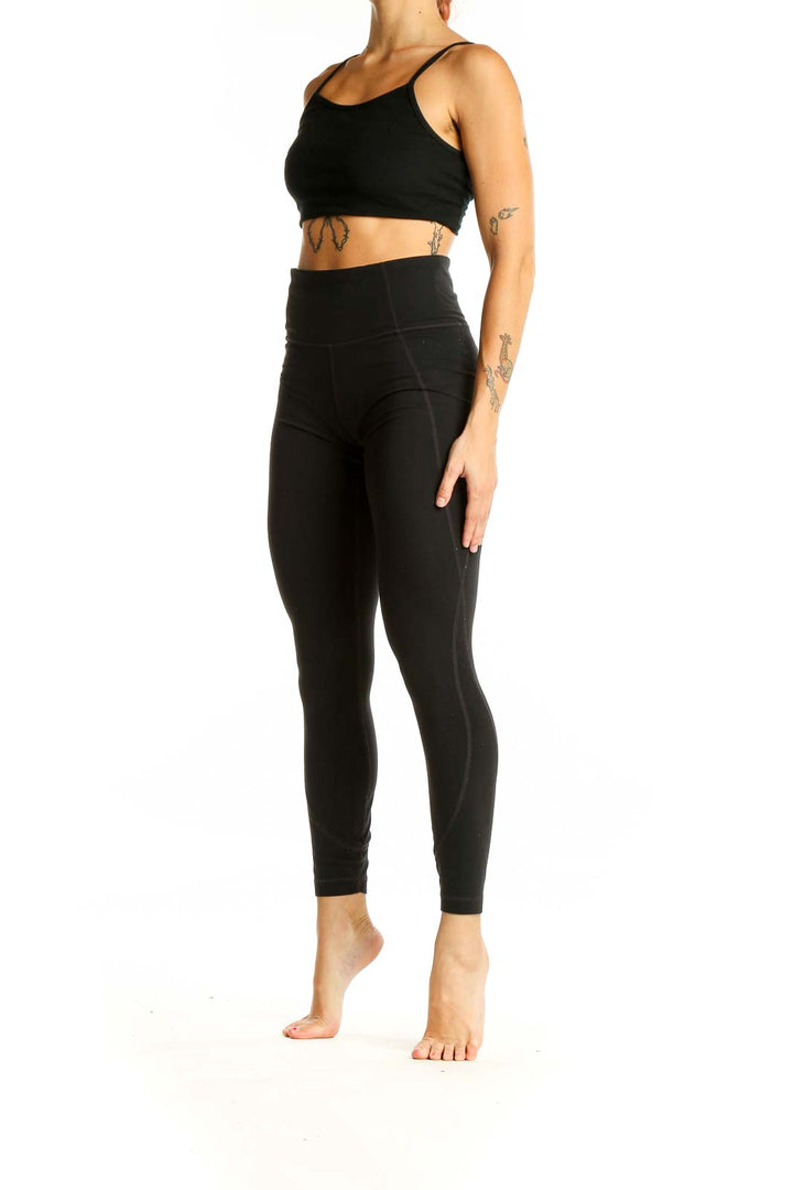 Front view of black high-waisted Athleta performance leggings on model