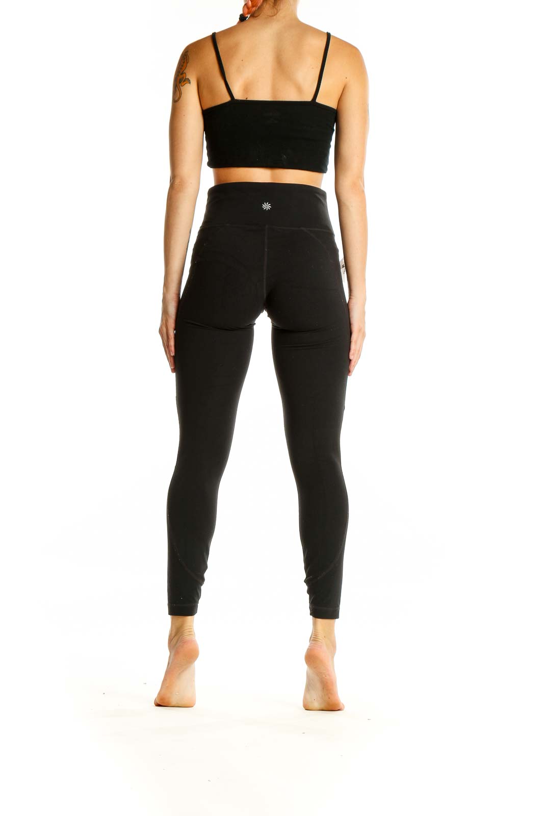 Back view of black high-waisted Athleta performance leggings on model