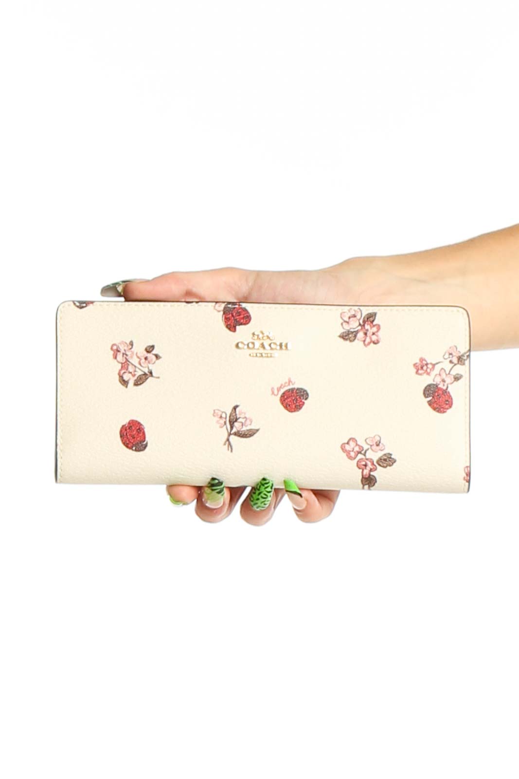 Front view of Coach cream leather clutch with floral and strawberry print