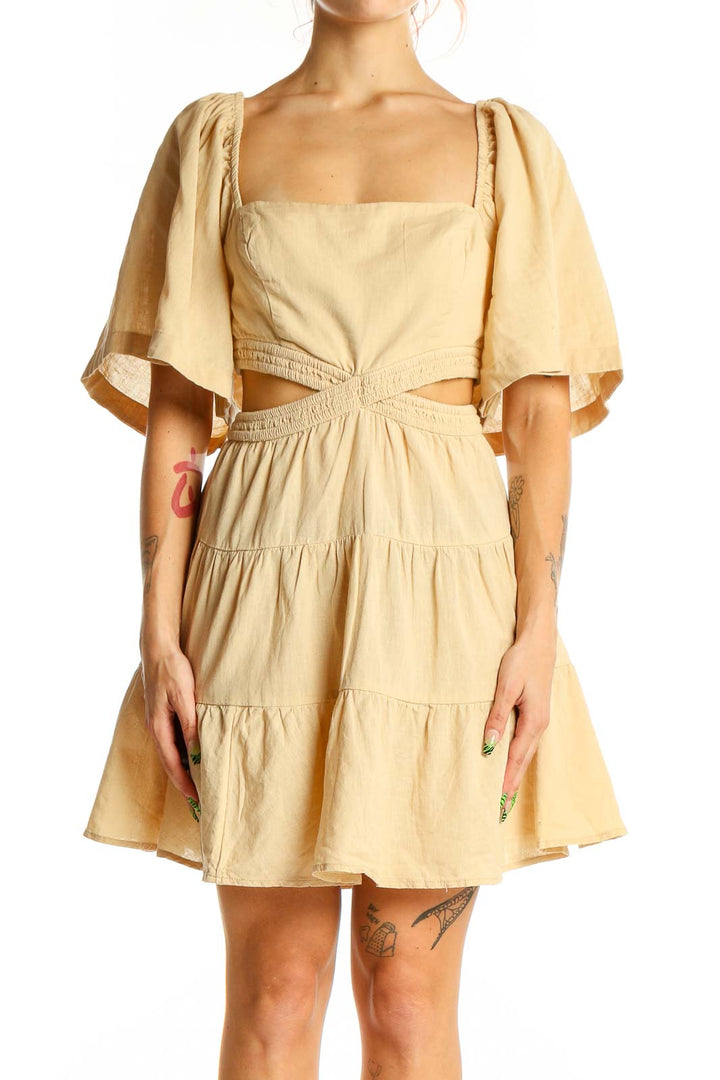 Front view of beige Free People mini dress with cutout waist and puff sleeves