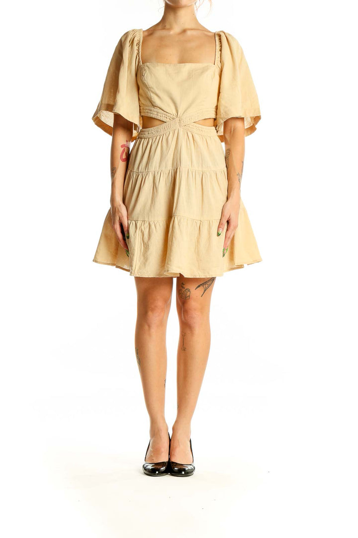 Front view of beige Free People mini dress with cutout waist and puff sleeves