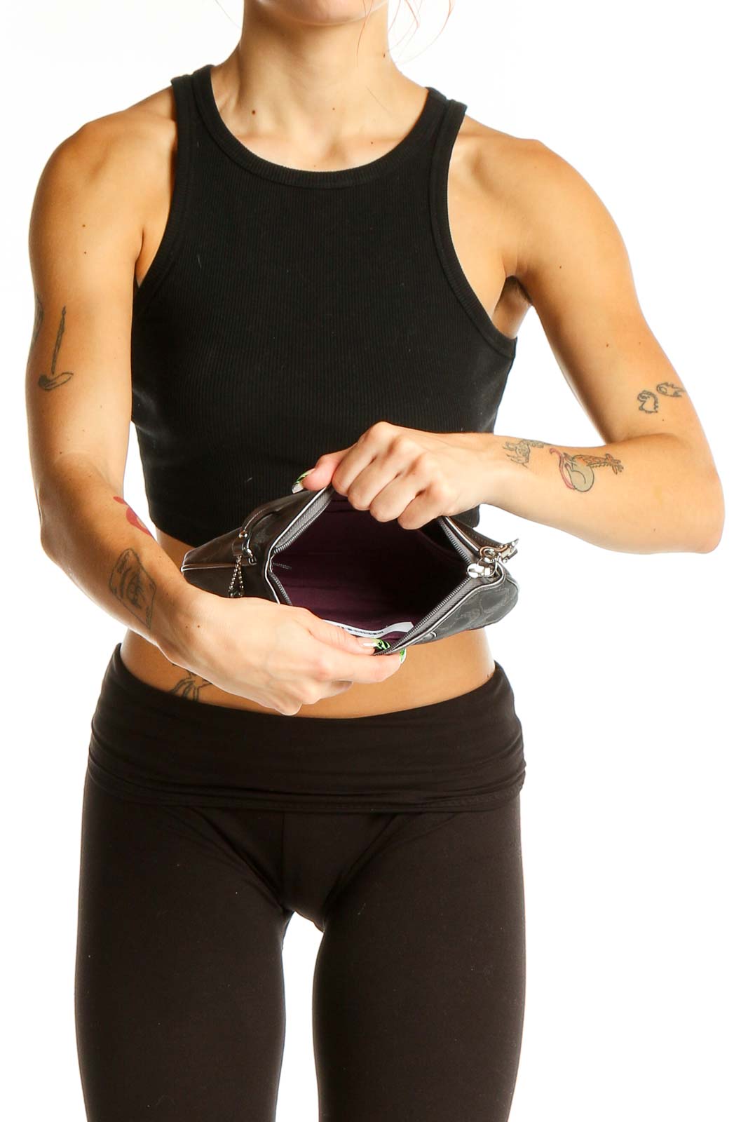 Woman holding gray Coach wristlet clutch, showcasing its size and style