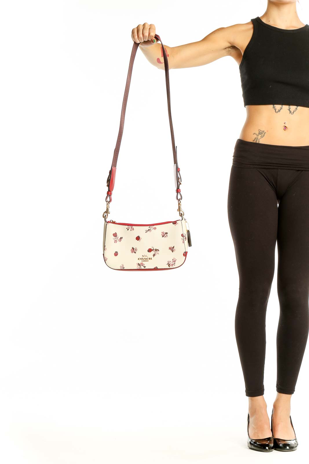 Front view of Coach cream crossbody bag with ladybug and floral print