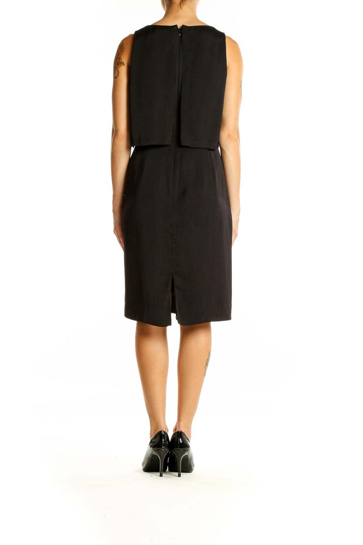 Back view of Madewell black sleeveless midi dress showing straight skirt and back slit