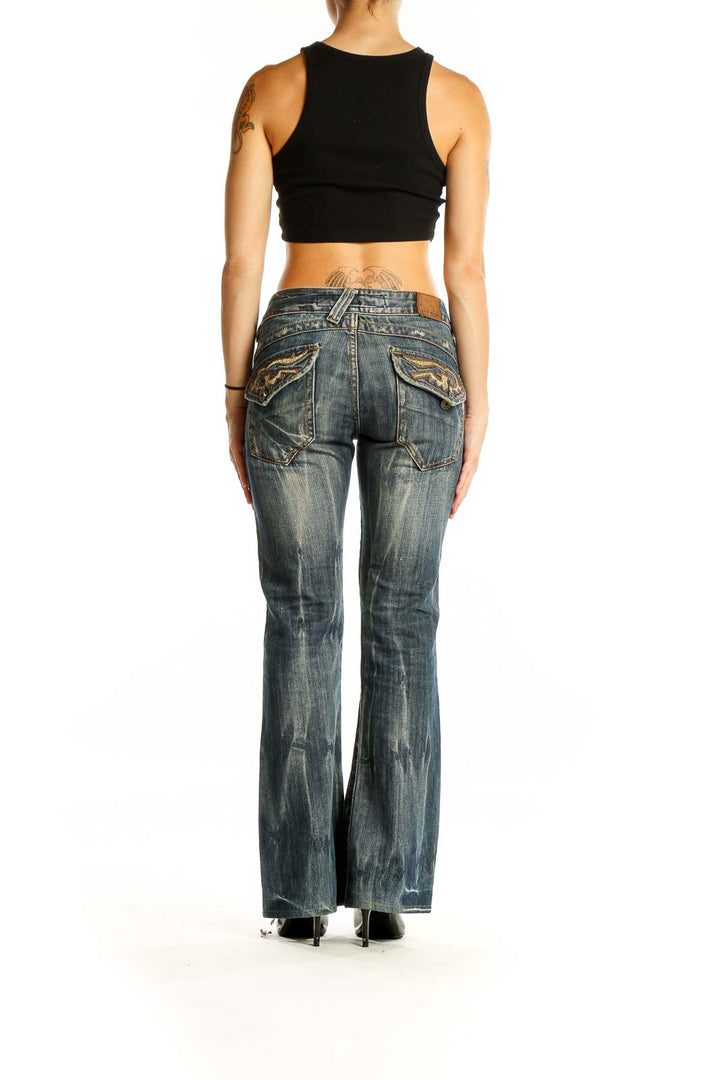 Back view of blue distressed flared jeans with embellished pockets by Drive Jeans