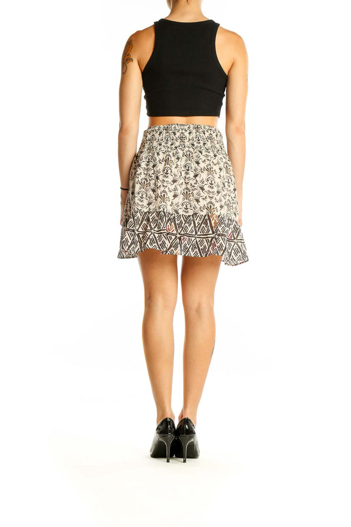 Back view of cream floral print mini skirt showing geometric hem detail