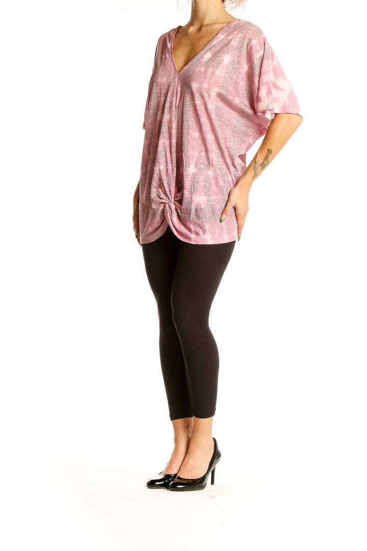 Front view of pink tie-dye V-neck oversized top with knotted hem