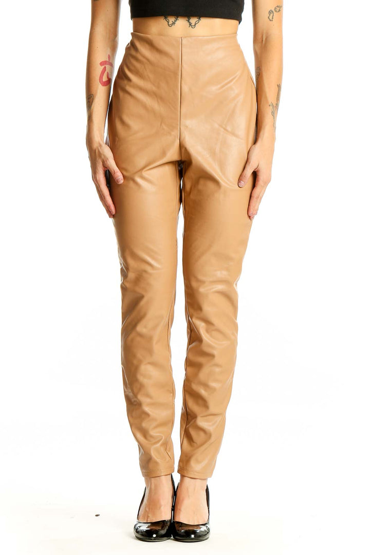 Front view of tan high-waisted faux leather pants from Express